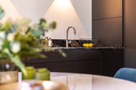 Brasilianischer Naturstein und matte Fronten prägen die Optik der Küche