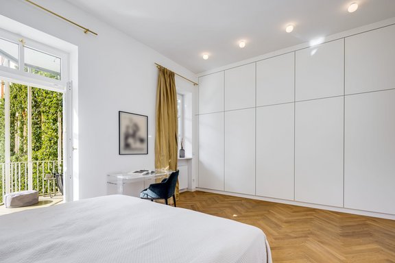 Im Schlafzimmer sorgt ein maßgeschreinerter Einbauschrank für Stauraum