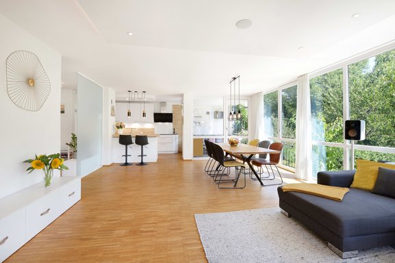 Der großzügige Wohn-/Essbereich mit anschließender Küche und grüner Traumkulisse bildet das Zentrum dieser Wohnung