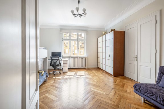 Zimmer mit altbautypischem Fischgrätparkett und Hohlkehl-Deckenstuck