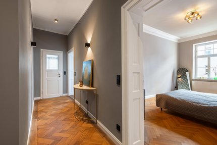 Flur mit Fischgrätparkett und Kassettentüren