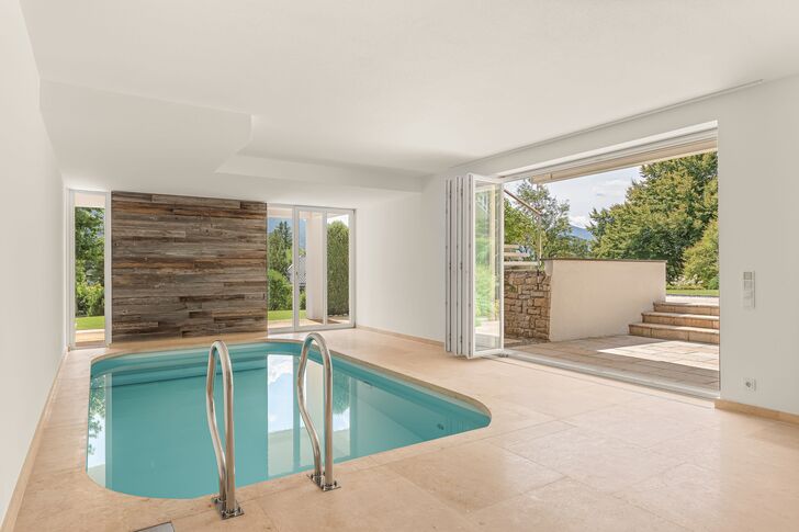 Lichtdurchfluteter Indoor-Pool mit direktem Gartenzugang