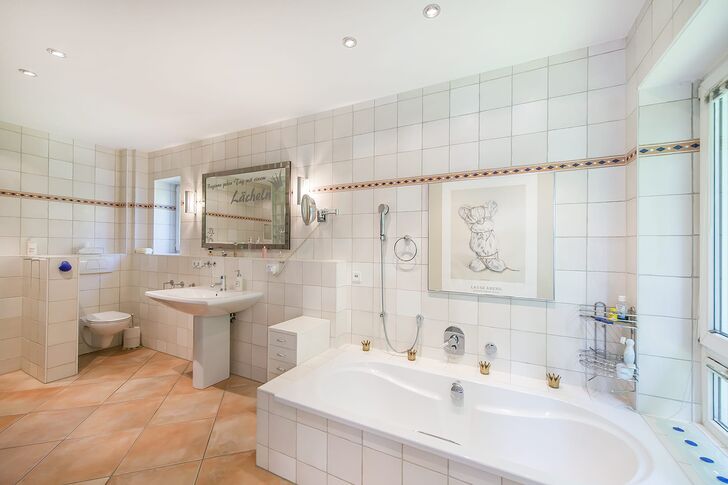 Mit Wanne und Dusche ausgestattetes und helles Bad