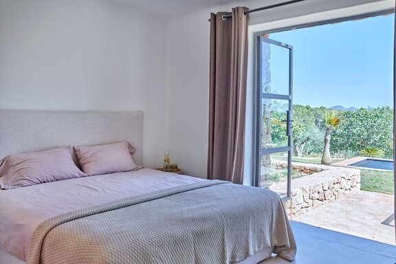 Schlafzimmer mit direktem Zugang zur Pool- und Gartenlandschaft