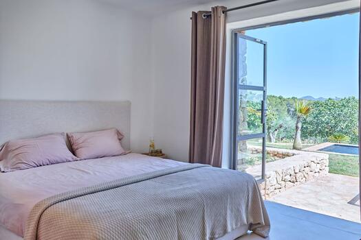 Schlafzimmer mit direktem Zugang zur Pool- und Gartenlandschaft