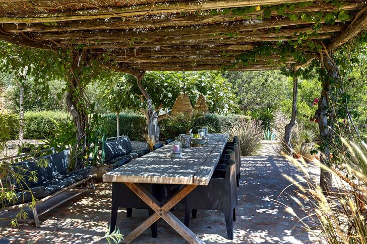 Idyllischer Essbereich unter einer bewachsenen Pergola
