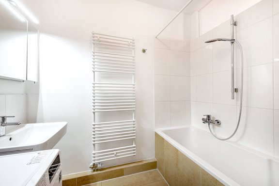 Timelessly designed bathroom with light natural stone floor tiles