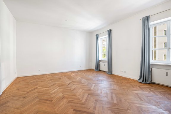 Imposante Raumhöhen und Fischgrätparkett unterstreichen das stilvolle Ambiente