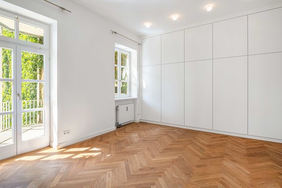 Im Schlafzimmer sorgt ein maßgeschreinerter Einbauschrank für Stauraum