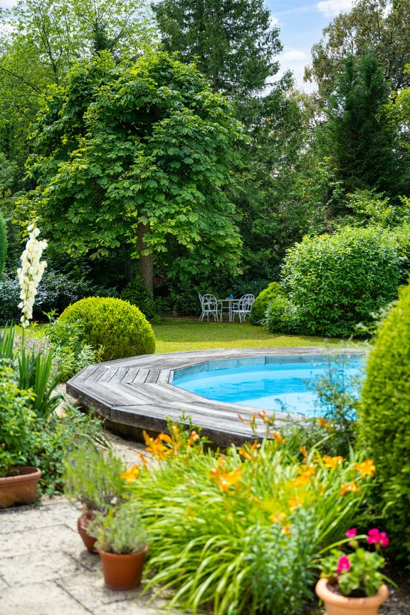 Grüne Sträucher und Hecken rahmen die sonnigen Rasenflächen ein