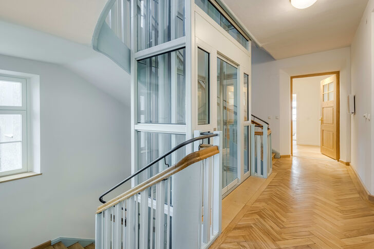 Ein moderner Glaslift führt in die erste Etage