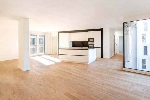 Die zeitlose Schreinerküche mit weißen Hochglanzfronten unterstreicht den Anspruch dieses Objekts