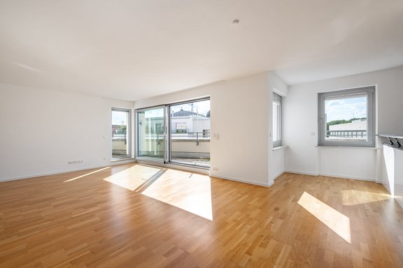 Wohnbereich mit Zugang zur zweiseitig umlaufenden Terrasse