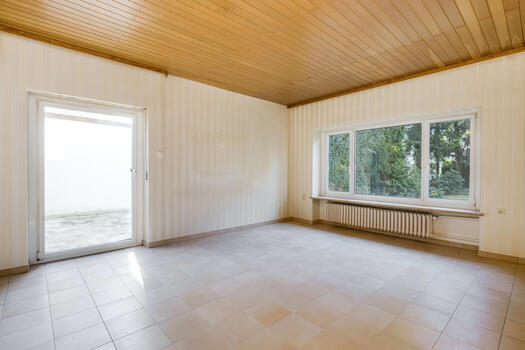 The spacious living room opens onto a sheltered terrace with garden views