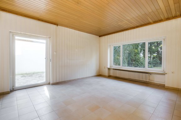 Das geräumige Wohnzimmer öffnet sich zu einer geschützten Terrasse mit Gartenblick