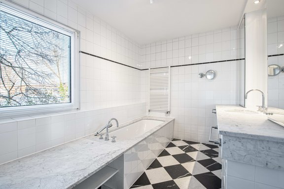 Elegant master bathroom with a window, bathtub, and shower