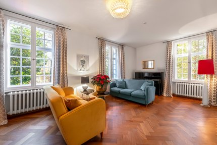 Gemütlicher Wohnbereich mit großen Sprossenfenstern