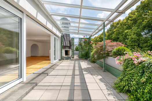 The charming roof terrace is a cozy outdoor oasis surrounded by greenery