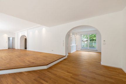 Rundbogen und Stufe definieren den Wohn-/Essbereich