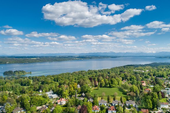 Blick über Feldafing – links die Roseninsel auf dem Starnberger See, hinten in der Ferne das Alpenpanorama