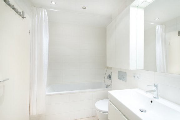 Bathroom with tub and custom carved wall fixtures