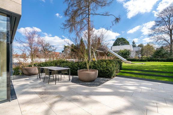 Sonnige Terrasse mit Natursteinfliesen