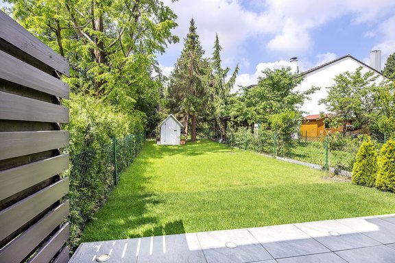 Sonniger West-Garten mit beleuchteter Terrasse