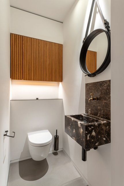 Gäste-WC mit Einbauten und Naturstein-Waschbecken