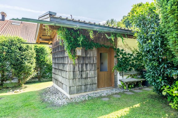 Praktische Gartenhütte mit Holzverschalung und überdachtem Sitzplatz