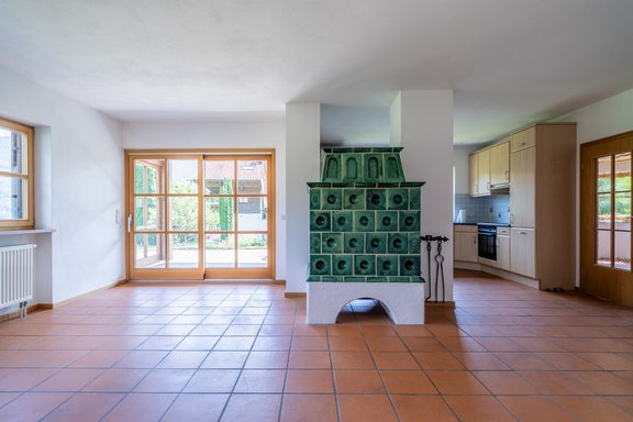 Offener Wohn- und Essbereich mit direktem Terrassenzugang und gemütlichem Kachelofen