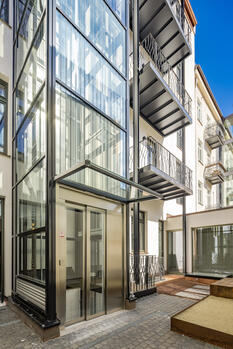 Modern glass lift in the inner courtyard