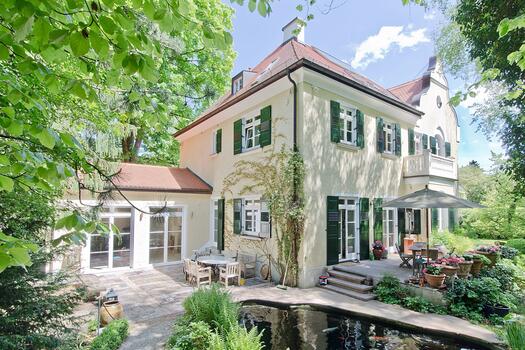 Hausansicht mit Teich und Anbau