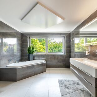 Großes Badzimmer mit Wanne und Dusche