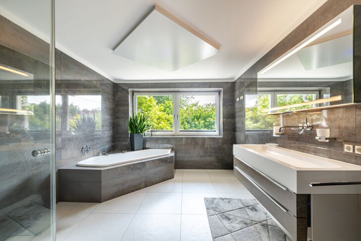 Großes Badzimmer mit Wanne und Dusche