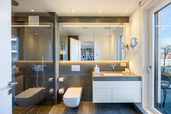 A light-filled natural stone shower room