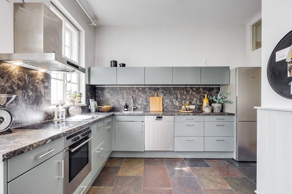 Wohnküche mit Natursteinboden und Einbauten