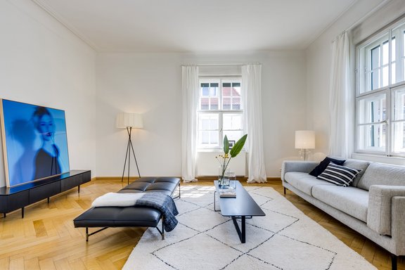 Mit Sprossenfenstern, Deckenstuck und Fischgrätparkett vermittelt das Wohnzimmer feinen Altbau-Charme