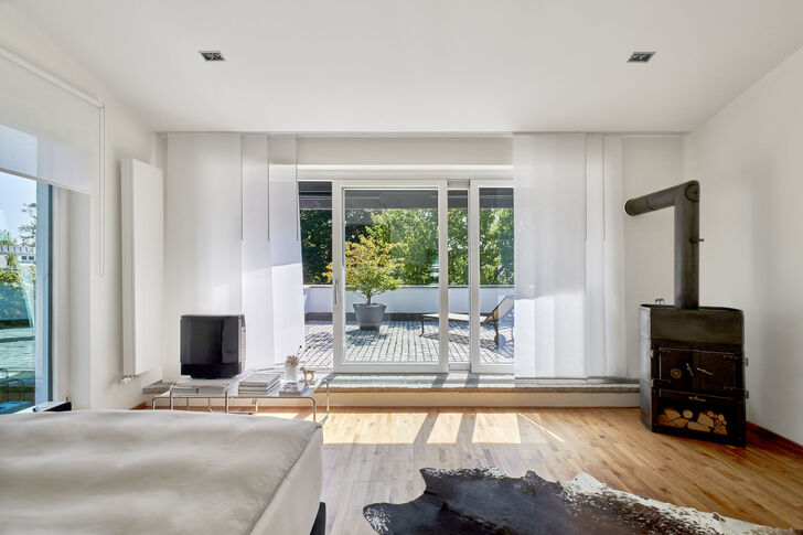 Mit Schwedenofen, Dachterrasse und Gartenblick begeistert das Masterschlafzimmer