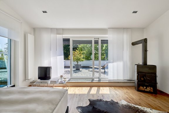 Mit Schwedenofen, Dachterrasse und Gartenblick begeistert das Masterschlafzimmer