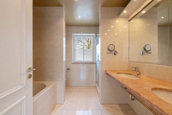 Badezimmer gestaltet mit hellen Fliesen und Marmor