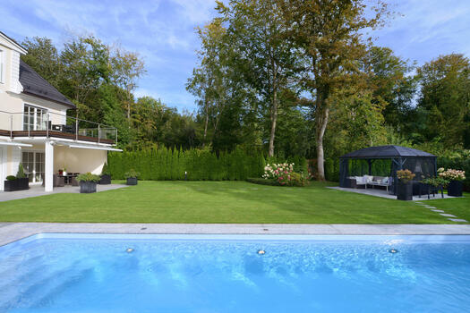 Garden, pool and outdoor seating directly on the edge of the forest