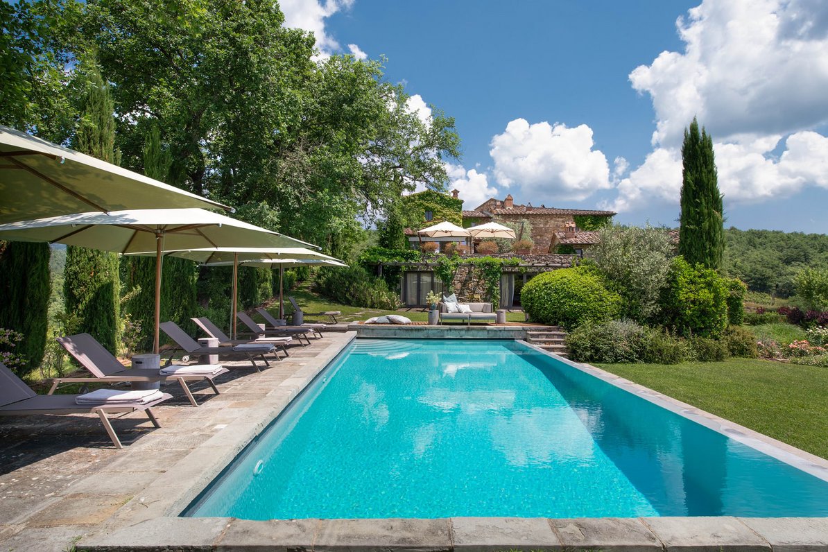 Sonniger Pool mit Blick auf das Anwesen