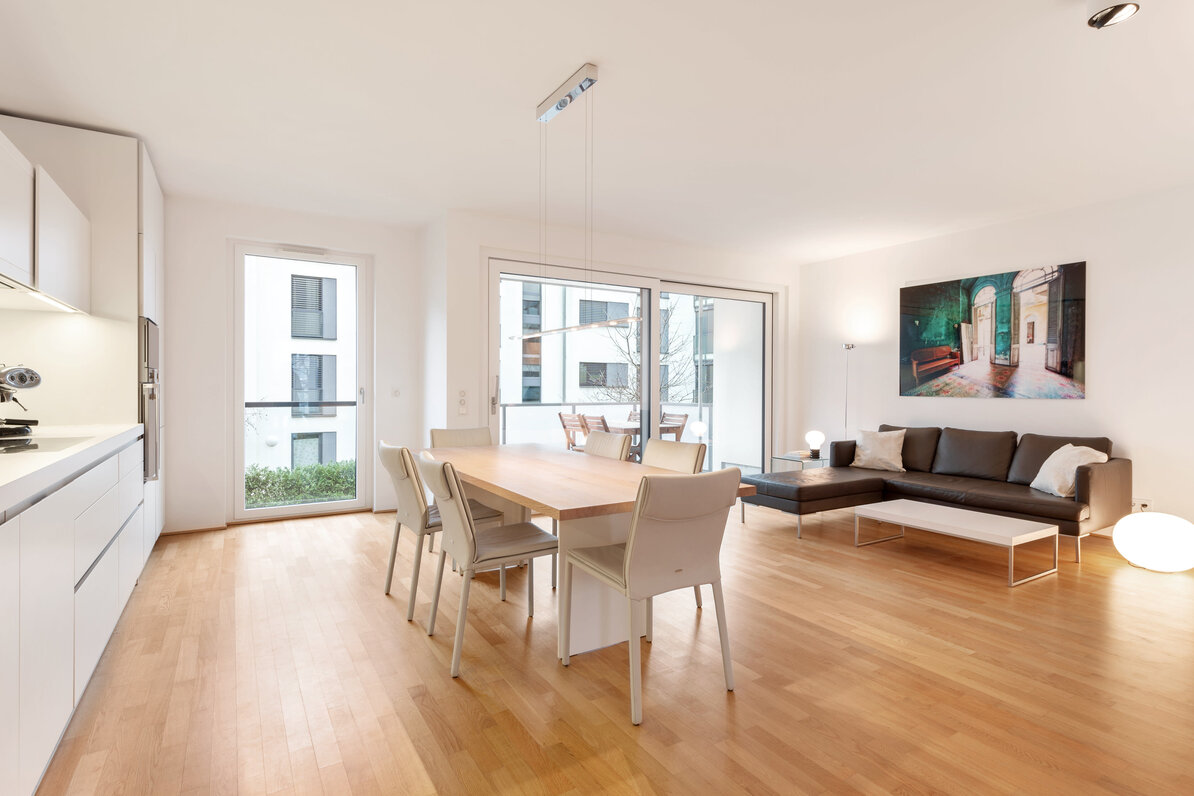 Open-concept living/dining/kitchen area with access to the west-facing balcony