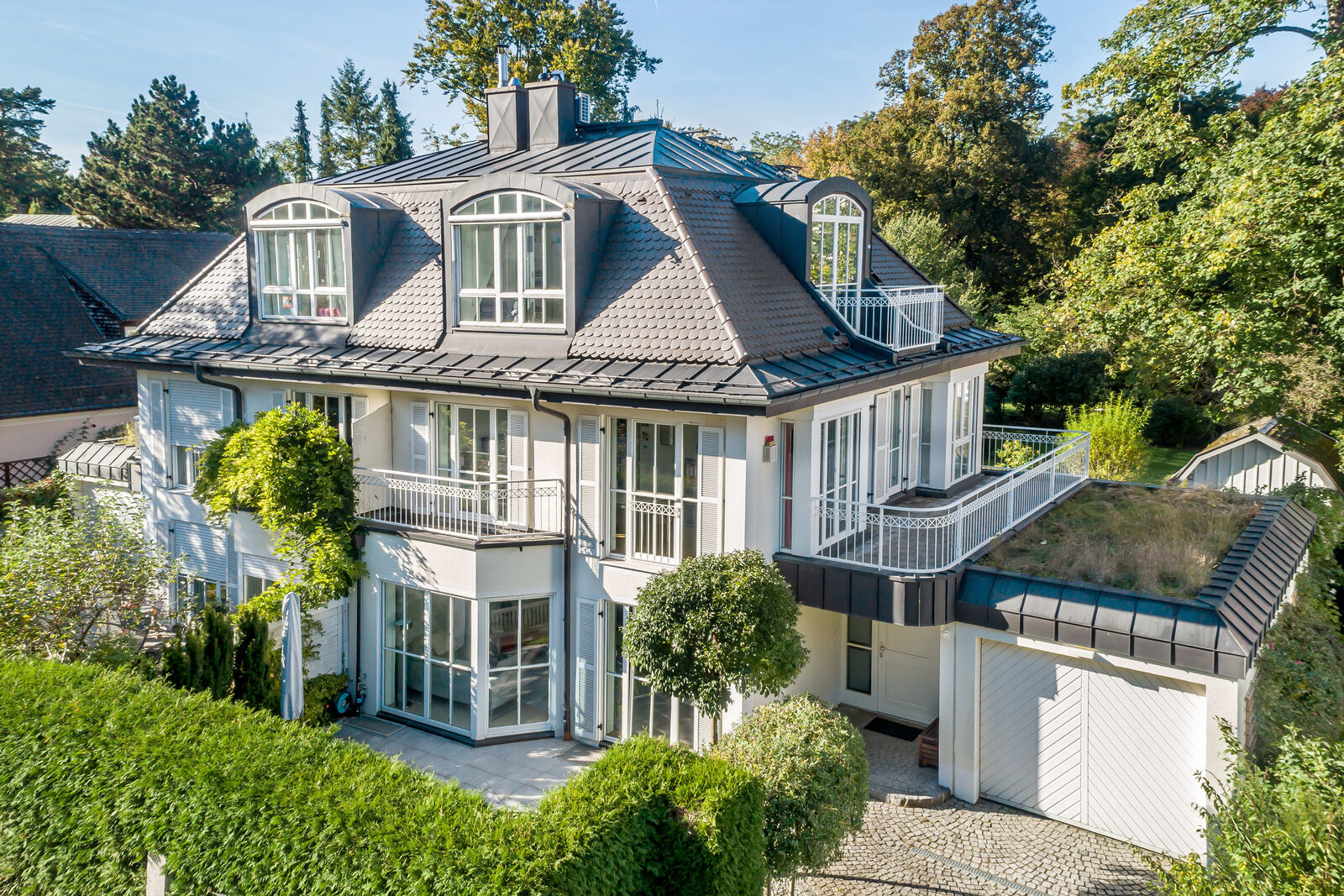 Die Fassade besticht mit Holzläden und Sprossenfenstern