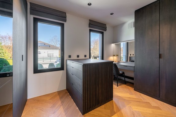 Ankleide in edler Ästhetik mit beleuchteter Vitrine und Make-up-Tisch