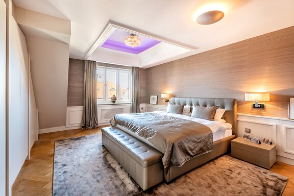 Masterschlafzimmer mit Wandpaneelierungen und raumhohen Schrankeinbauten