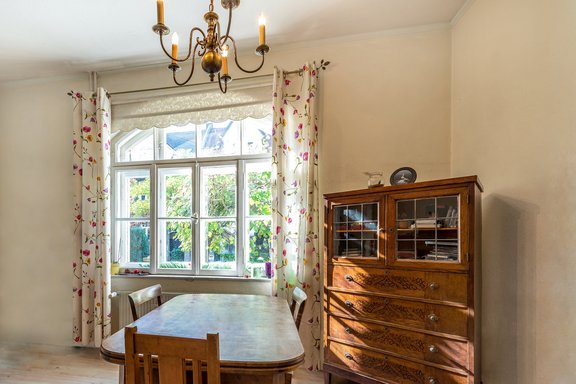 Sonniges Wohnzimmer mit historischem Rundbogenfenster