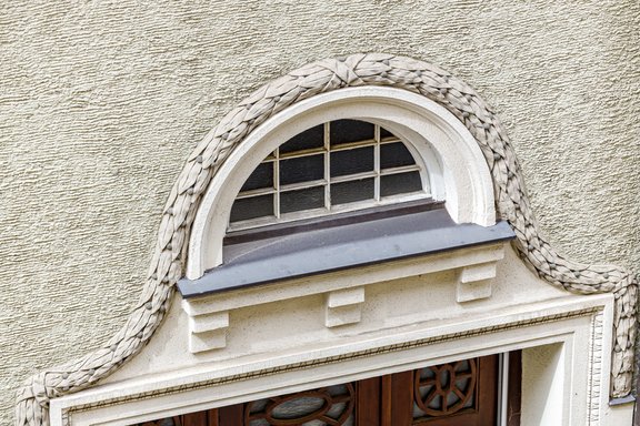 Historische Rundbogenfenster und Putzfaschen