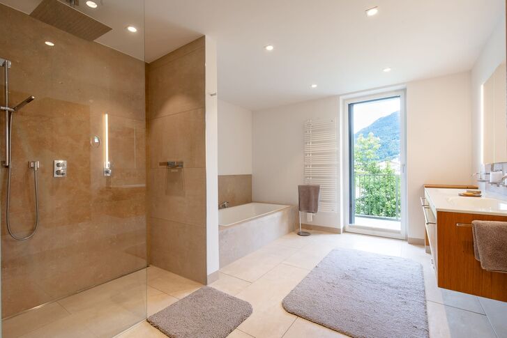 Großzügiges Bad mit Naturstein und Ausblick