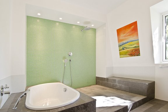 Badezimmer mit offener Dusche und Badewanne